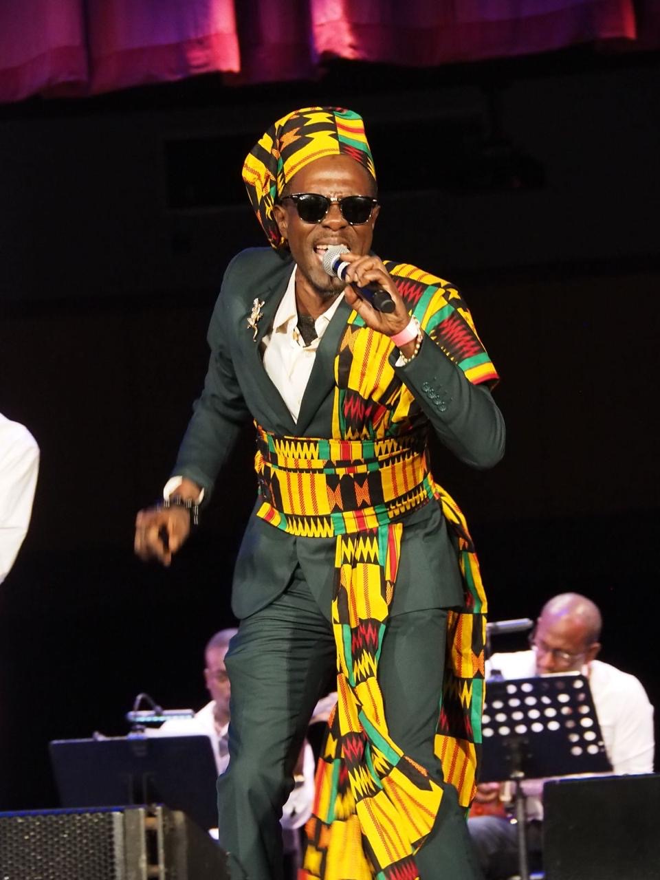 Banjela performing live on stage in a colorful African-inspired outfit
